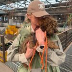 Teilnehmerin des Erste Hilfe am Hund RUDEL.-Workshops küsst ihren Pudel während eines Testimonial-Videos