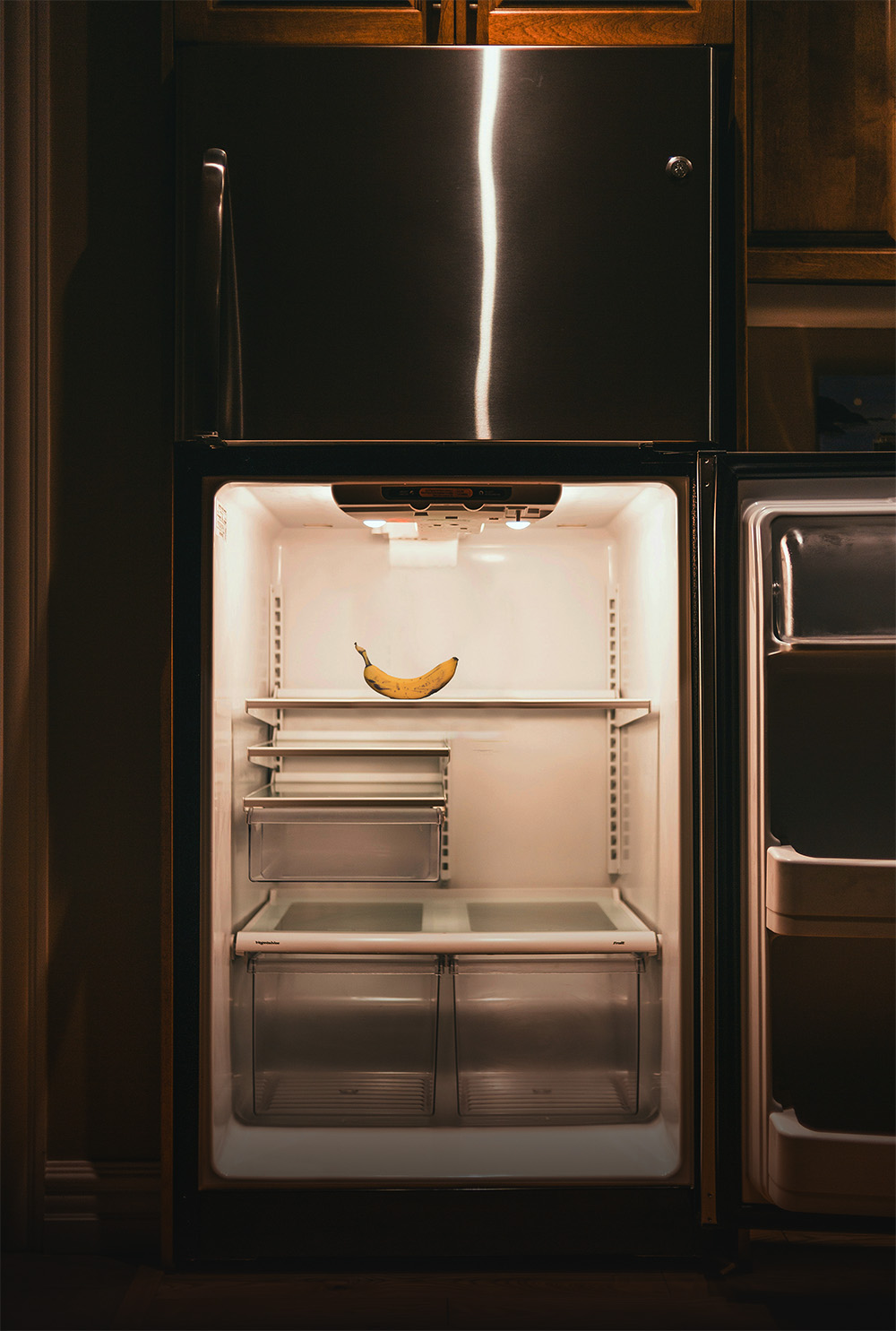 Offener, fast leerer Kühlschrank mit einer einzelnen Banane. - Cover aus der Rubrik "Vorsorge & Rechtliches"