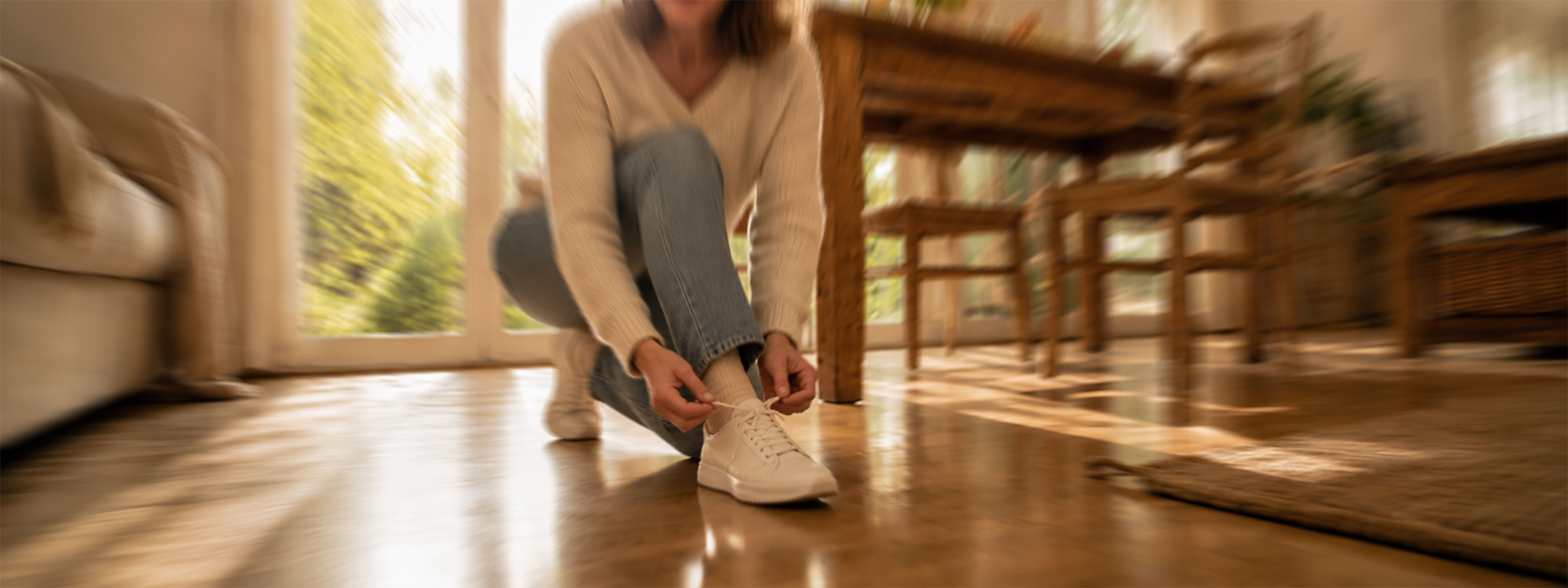Frau bindet sich die Schuhe zu, Welpe schaut zu