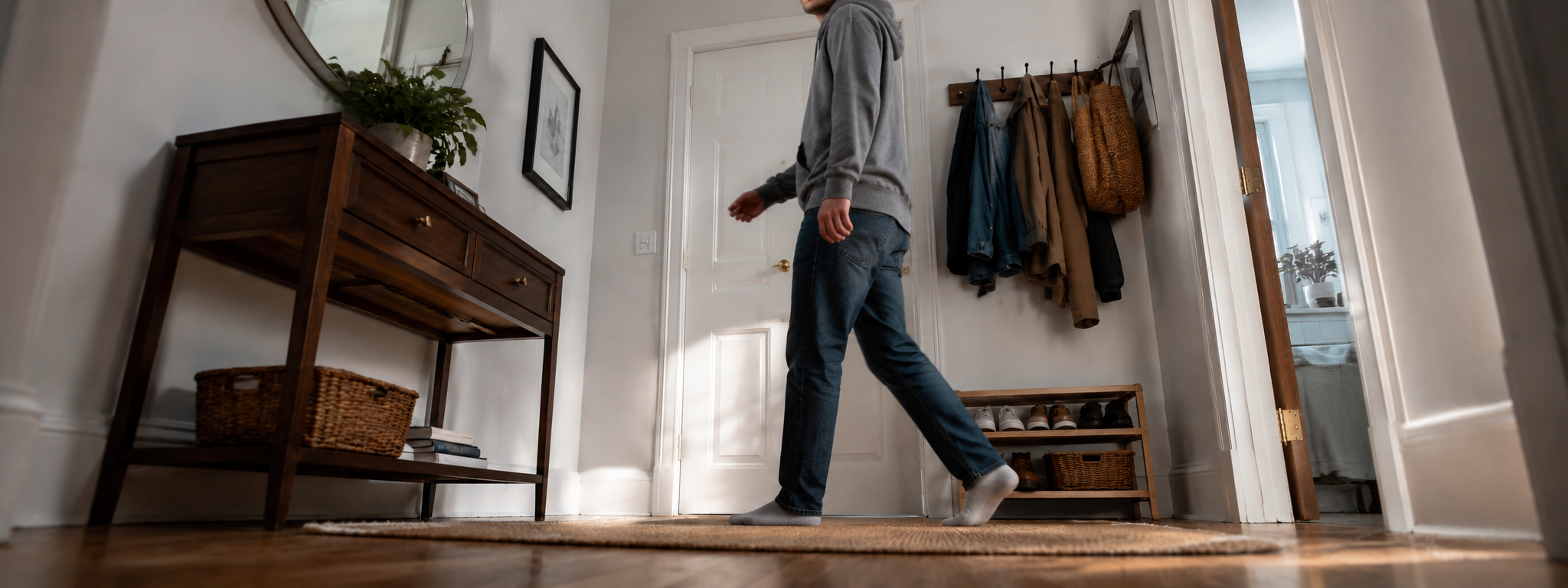 Mann zieht abends im Flur seine Jacke an, bereit zum Verlassen der Wohnung