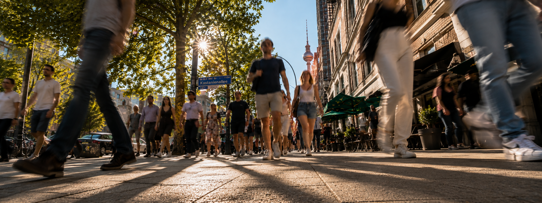 Viele Menschen laufen auf einer belebten Straße direkt auf die Kamera zu, aufgenommen aus niedriger Welpenperspektive